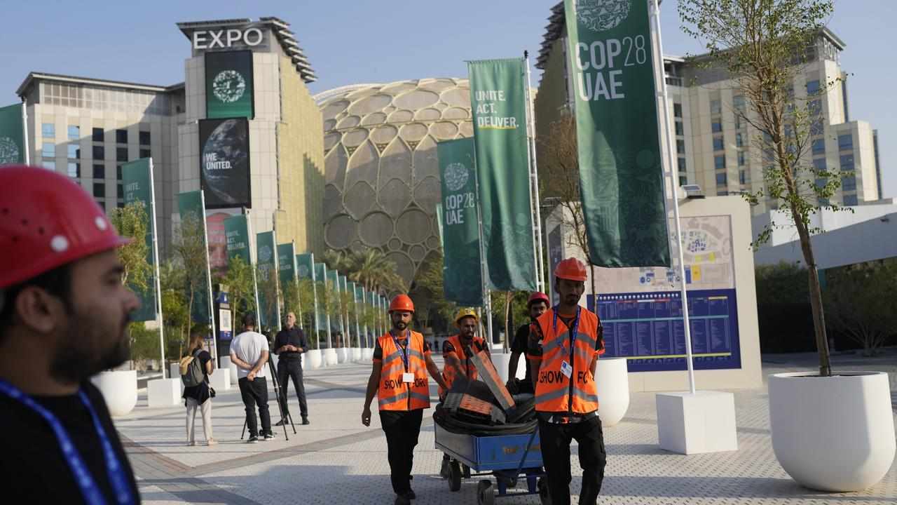 Workers move items as the COP28 U.N. Climate Summit comes to an end