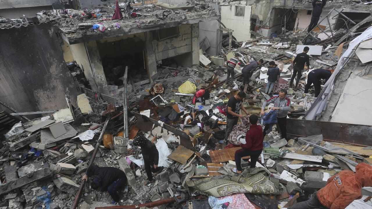 Palestinians salvage their belongings after an Israeli strike in Rafah