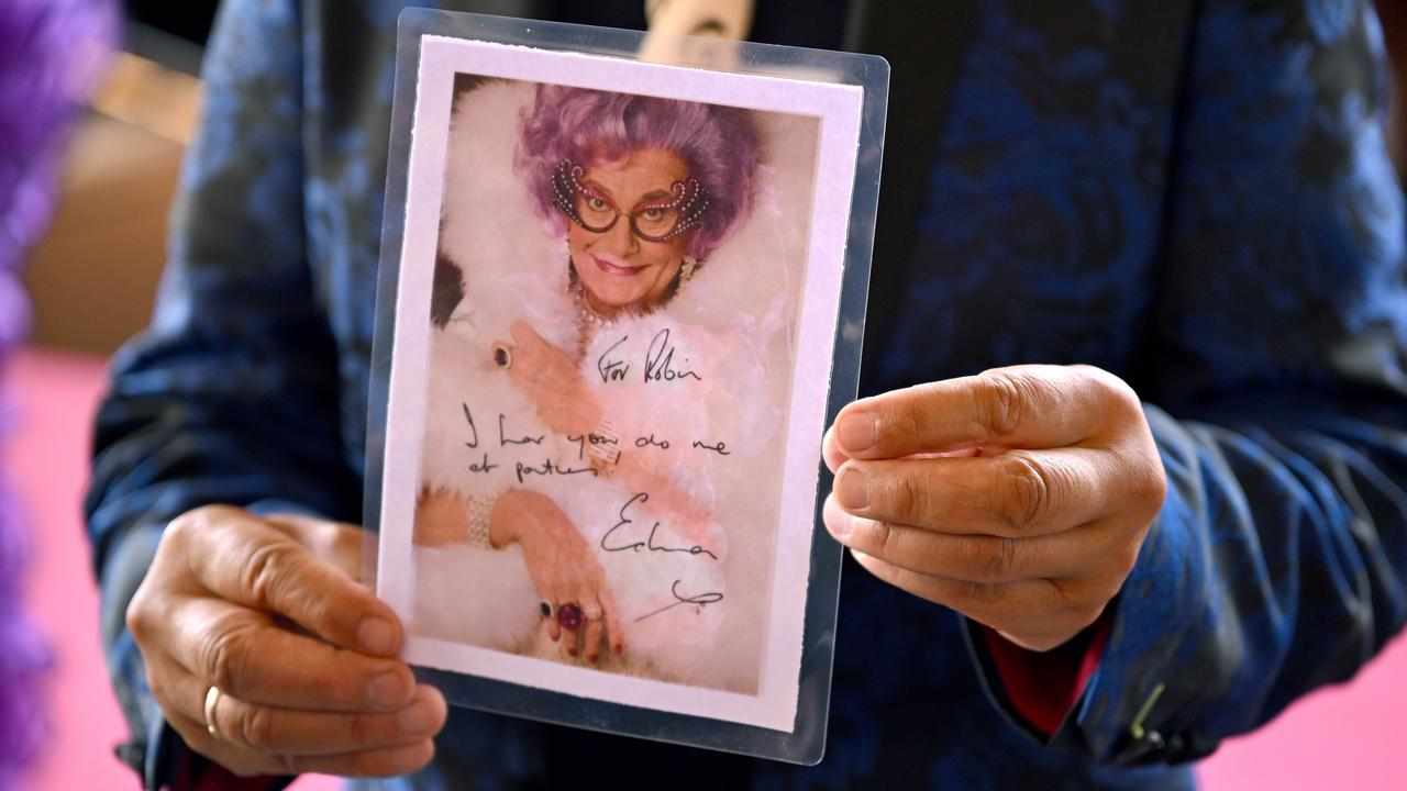 Memorial attendee holds a personalised message from Dame Edna.