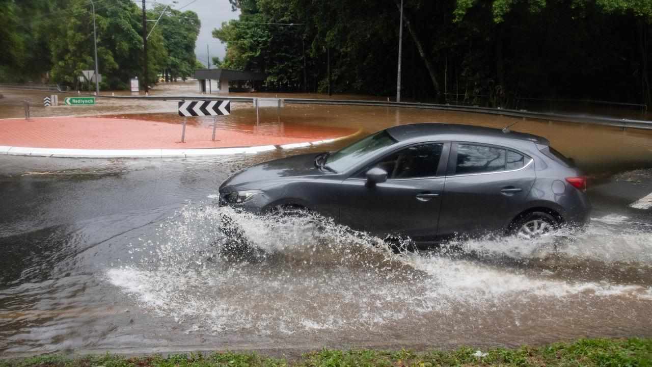 A car drives along a flooded road.