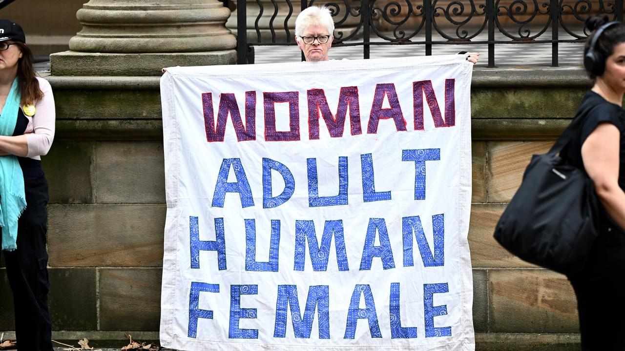 A protestor against transgender rights holds a banner