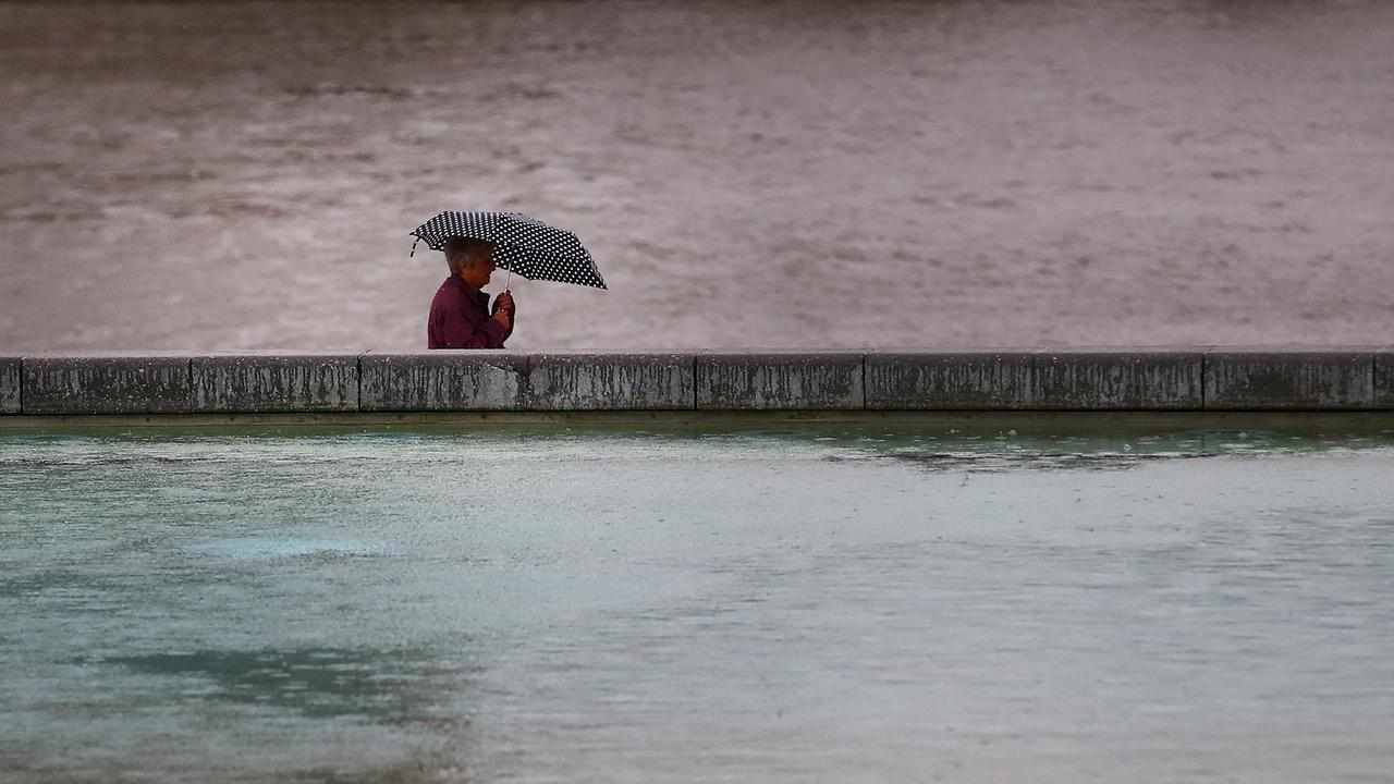 A pedestrian walks in the rain