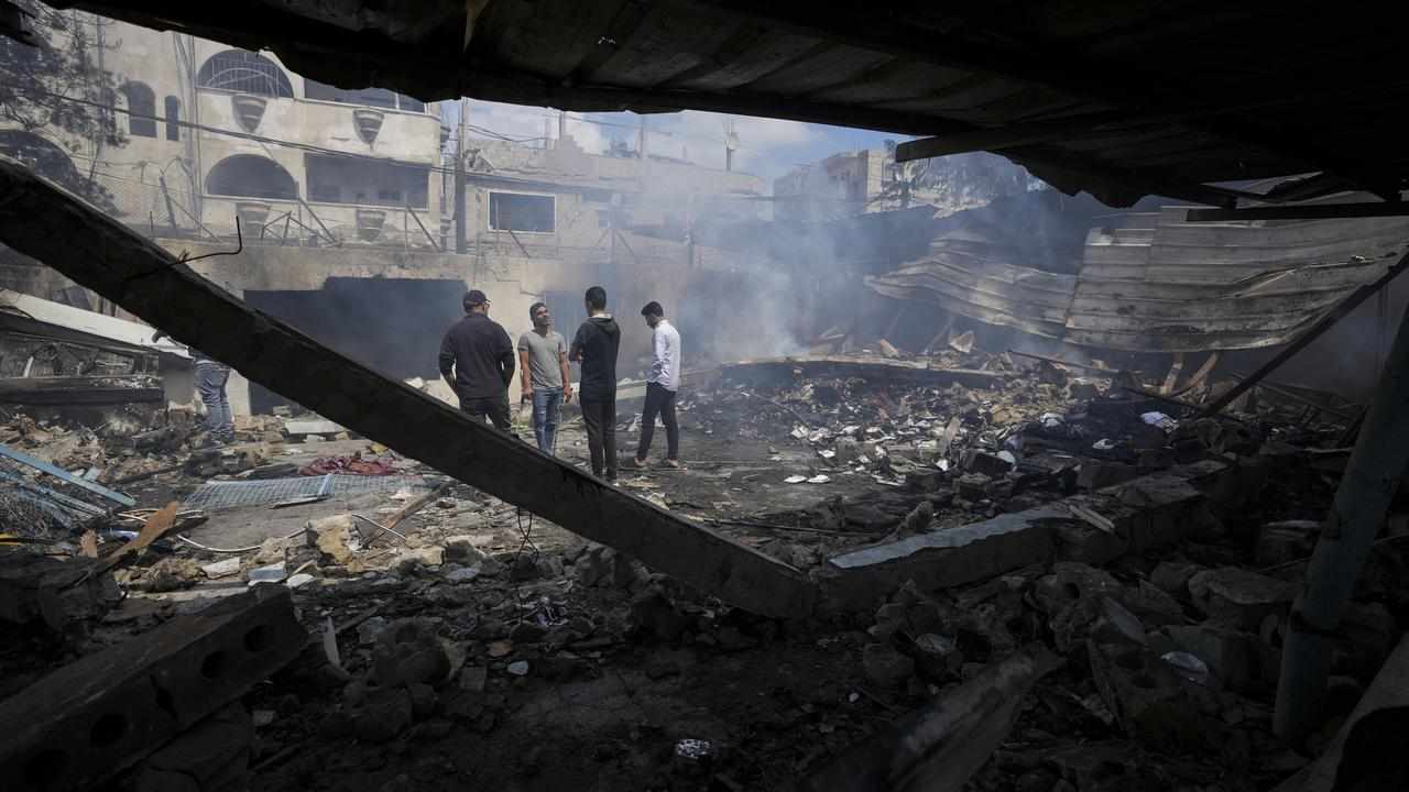 Palestinians look at destruction after an Israeli strike on a school.
