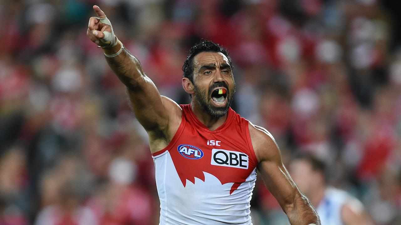 AFL player Adam Goodes holds up his hand during a game.